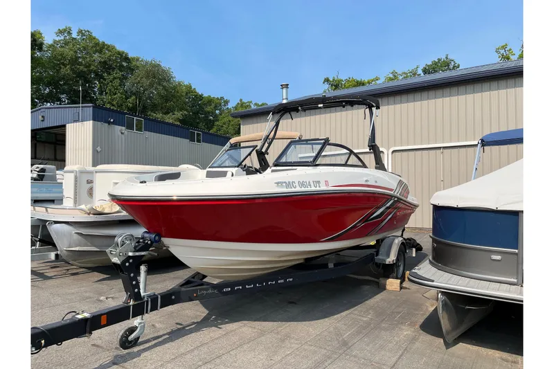 The Image of 2022 Bayliner VR5 Bowrider I/O boat on trailer, parked outdoors near storage facility. - 0