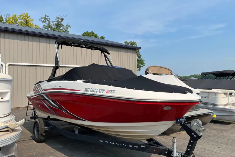 Slide: The Image of 2022 Bayliner VR5 Bowrider I/O boat with cover on trailer, parked outdoors. - 1