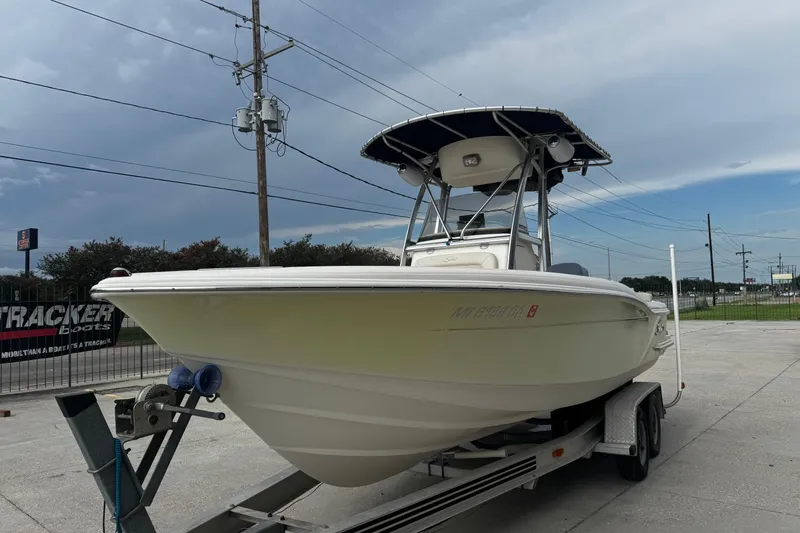 Slide: The Image of 2006 Scout 222 Sportfish boat on trailer, parked outdoors under cloudy sky. - 6