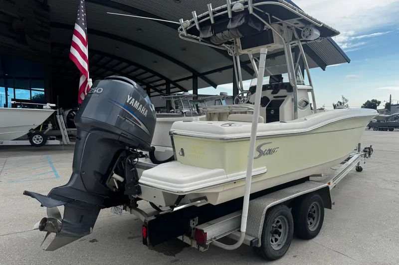 Slide: The Image of 2006 Scout 222 Sportfish boat with Yamaha engine on trailer, parked outdoors. - 2