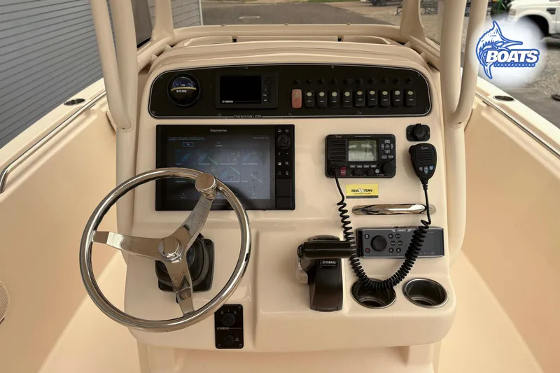 Slide: The Image of 2018 Grady-White Fisherman 216 boat dashboard with steering wheel and navigation controls. - 6