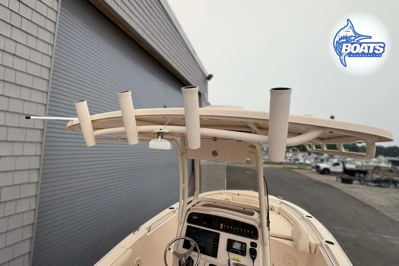 Slide: The Image of 2018 Grady-White Fisherman 216 boat with rod holders and console, parked near a building. - 9