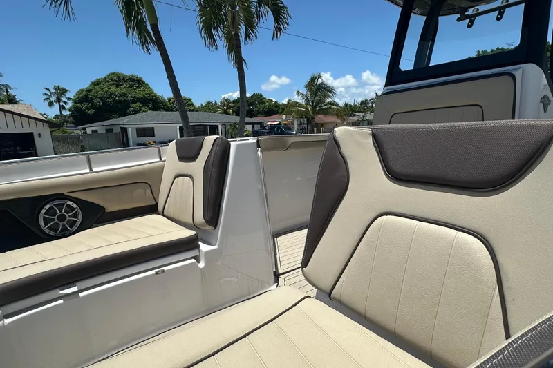 Slide: The Image of 2024 Yamaha Boats 255 FSH Sport H interior seating with palm trees in background. - 6