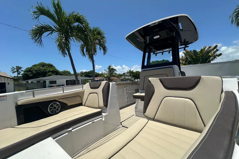 Slide: The Image of 2024 Yamaha Boats 255 FSH Sport H interior with seating and console, under clear blue sky. - 7