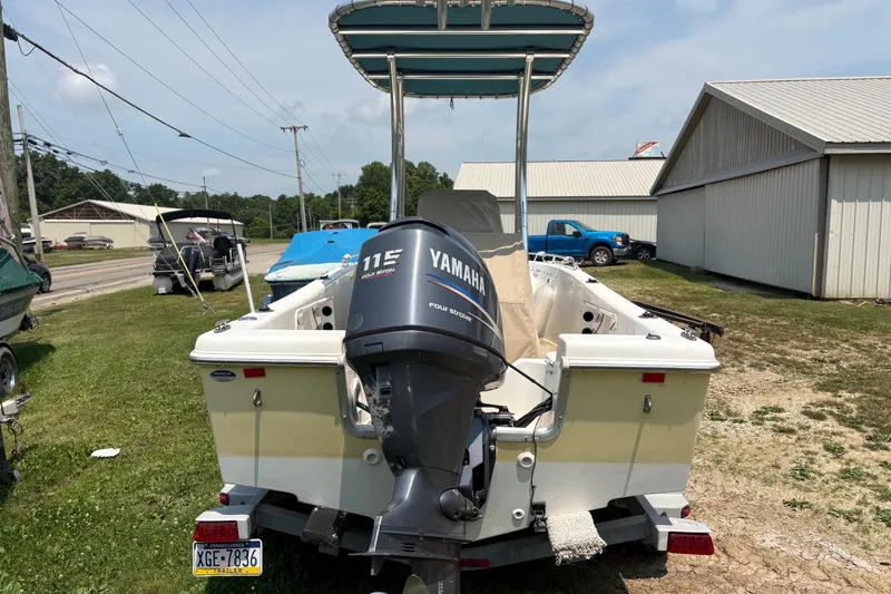 Slide: The Image of 2011 Clearwater 1900 Center Console boat with Yamaha 115 engine, parked outdoors. - 2
