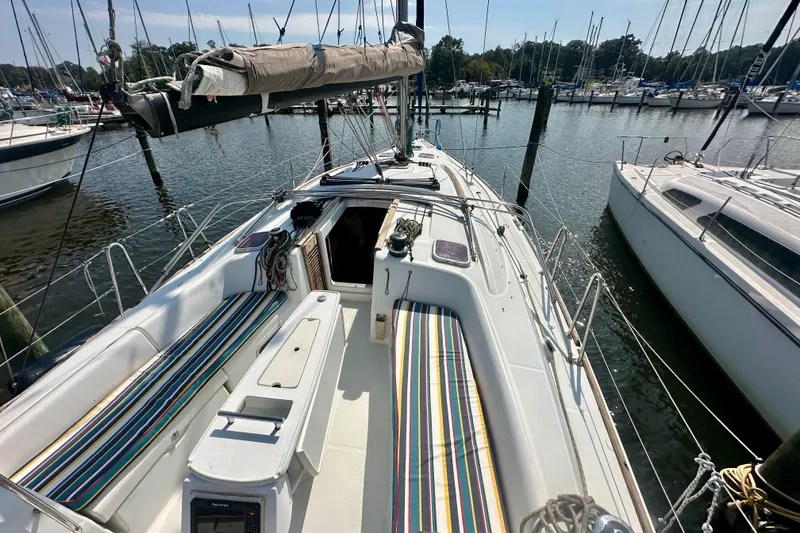 Slide: The Image of 2010 Beneteau Oceanis 40 sailboat docked, featuring spacious deck and colorful seating. - 14