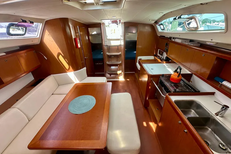 Slide: The Image of Interior of 2010 Beneteau Oceanis 40 yacht with kitchen, dining area, and wooden cabinetry. - 42