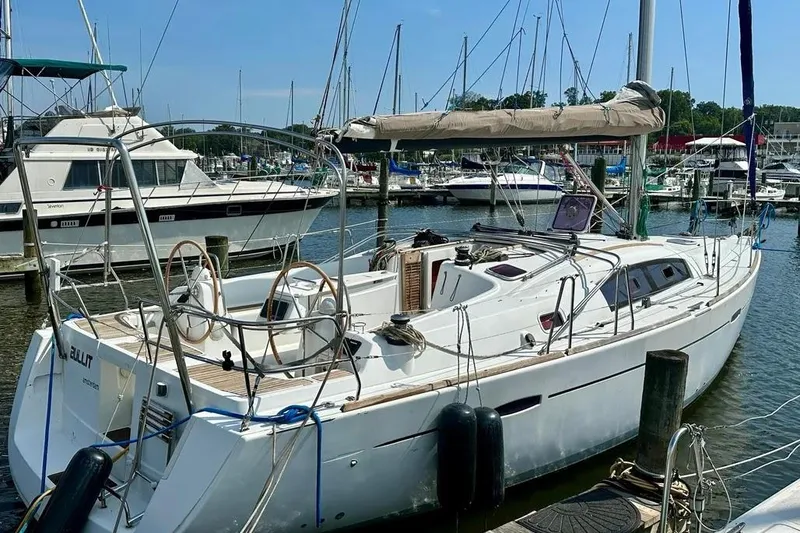 Slide: The Image of 2011 Beneteau Oceanis 40 sailboat docked in a marina, featuring dual steering wheels. - 6