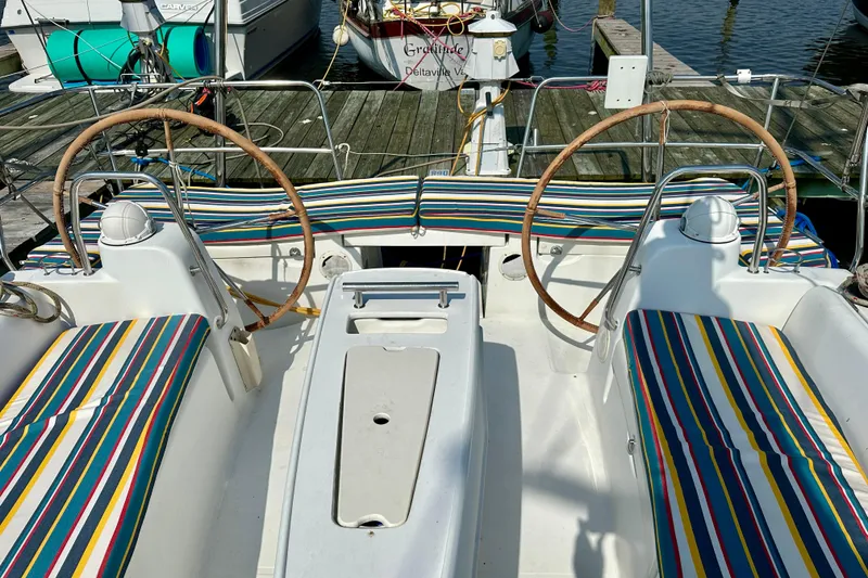 Slide: The Image of Cockpit of 2010 Beneteau Oceanis 40 sailboat with striped cushions and dual steering wheels. - 16
