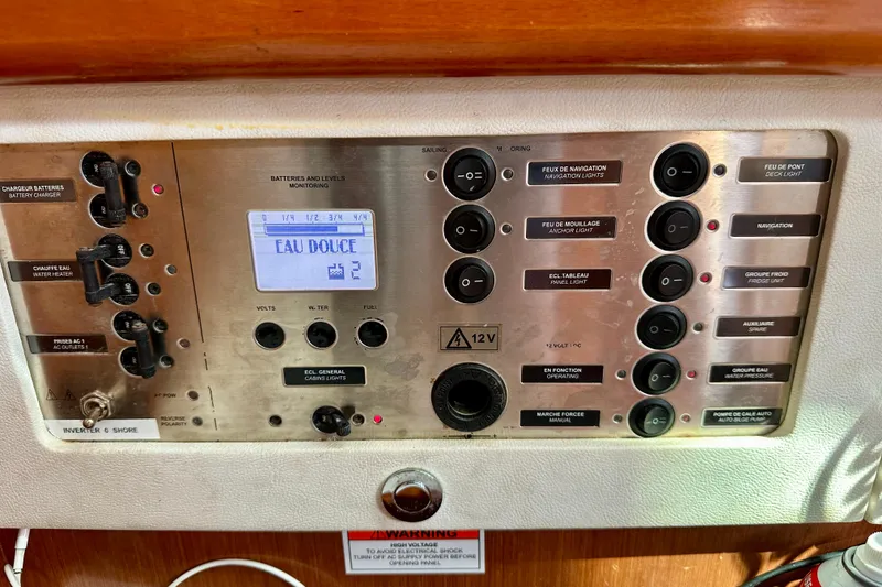 Slide: The Image of Control panel of a 2010 Beneteau Oceanis 40 sailboat, featuring various switches and indicators. - 46