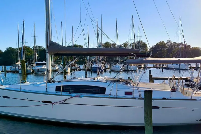 Slide: The Image of 2011 Beneteau Oceanis 40 sailboat docked in a marina, surrounded by other boats. - 4