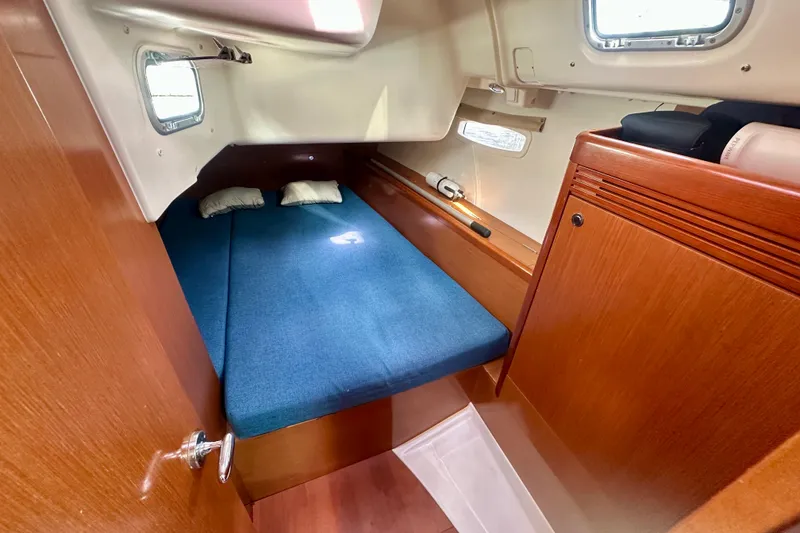 Slide: The Image of Cabin interior of 2010 Beneteau Oceanis 40 with blue bedding and wooden finish. - 50