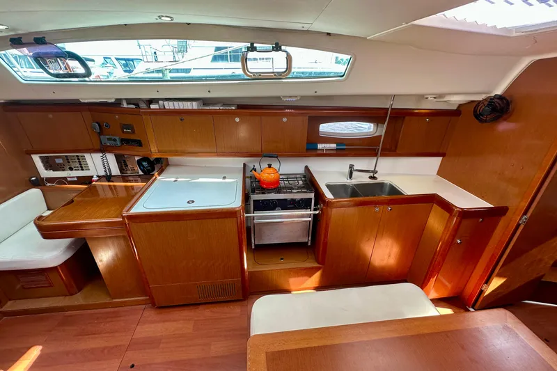 Slide: The Image of Interior of 2010 Beneteau Oceanis 40 yacht kitchen with wooden cabinetry and modern appliances. - 39