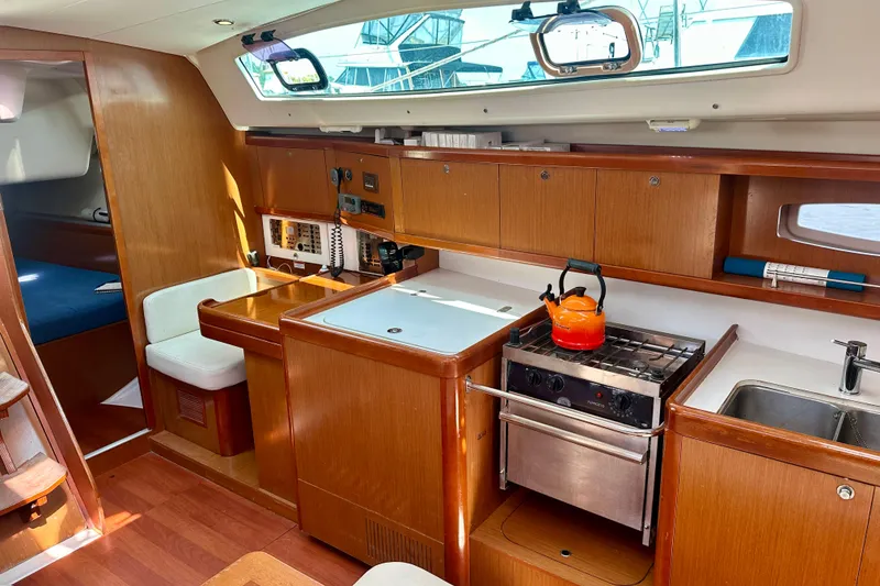 Slide: The Image of Interior of 2010 Beneteau Oceanis 40 yacht with kitchen and seating area. - 44