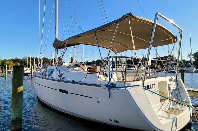 Slide: The Image of 2011 Beneteau Oceanis 40 sailboat docked in a marina under clear blue skies. - 2