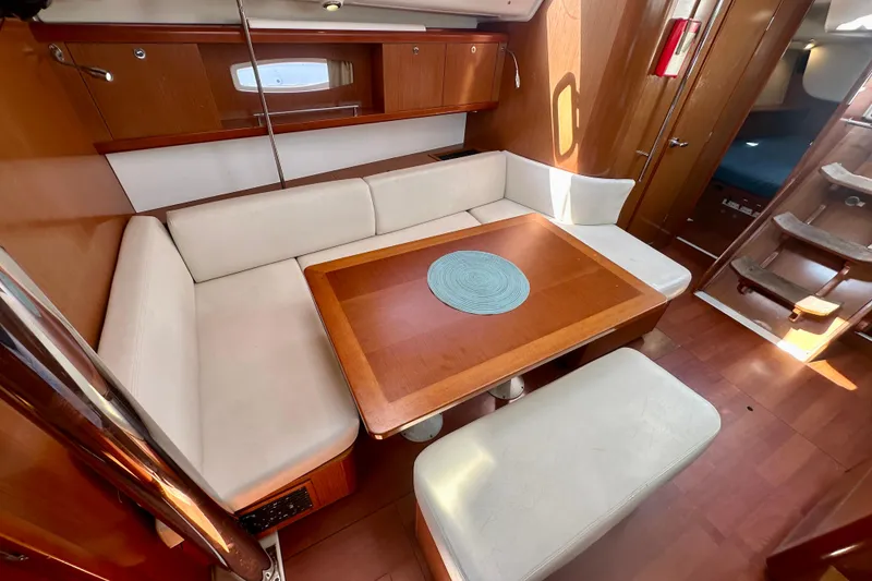 Slide: The Image of Interior of 2010 Beneteau Oceanis 40 sailboat with cozy seating and wooden table. - 41