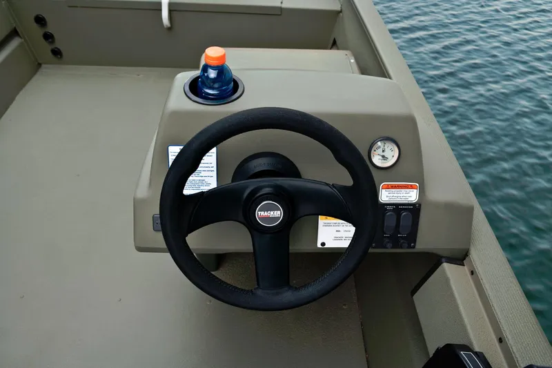 Slide: The Image of The image shows the helm of a Tracker Grizzly 1754 SC boat with a steering wheel and instruments. - 16