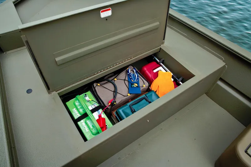 Slide: The Image of An open storage compartment on a boat reveals batteries, cables, and other gear. - 22