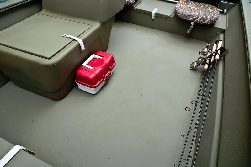 Slide: The Image of The image shows the interior of a Tracker Grizzly 1754 SC boat with fishing gear and a red cooler. - 24