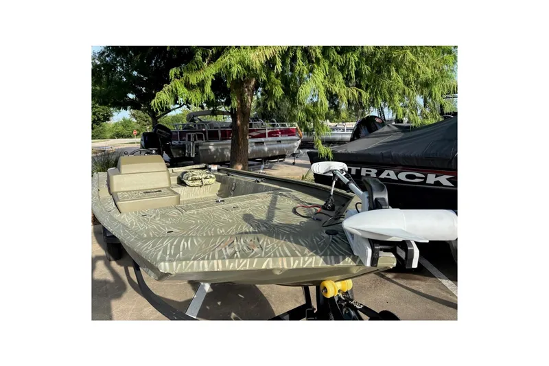 Slide: The Image of 2014 Tracker Grizzly 1754 SC boat with camouflage design, parked outdoors. - 32