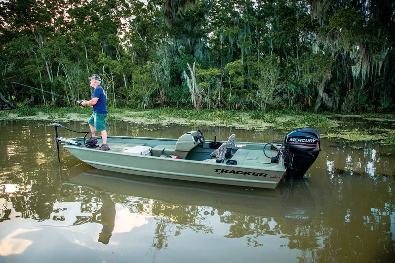 The Image of A man fishes on a Tracker Grizzly 1754 SC boat in calm, wooded waters. - 11