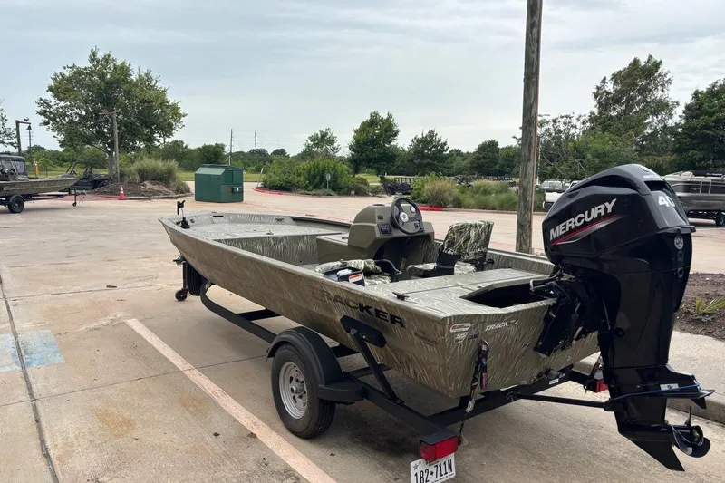 Slide: The Image of 2014 Tracker Grizzly 1754 SC boat with Mercury engine on trailer in parking lot. - 2