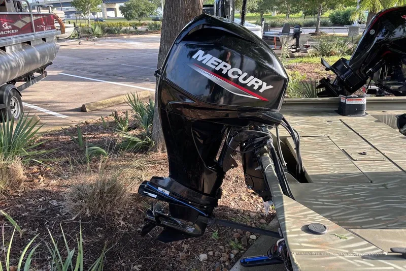 Slide: The Image of 2014 Tracker Grizzly 1754 SC boat with Mercury outboard motor in a parking area. - 10
