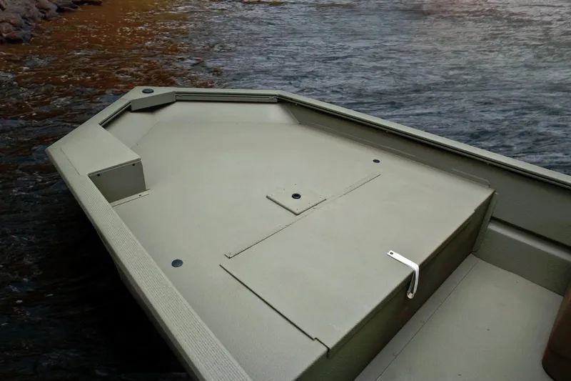 Slide: The Image of The image shows the deck of a Tracker Grizzly 1754 SC boat on calm water. - 30