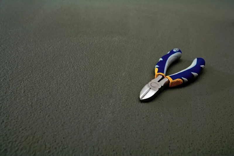 Slide: The Image of A pair of pliers rests on a textured surface. - 25