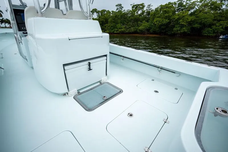 Slide: The Image of 2019 Conch 33 boat interior with storage compartments, near lush shoreline. - 36