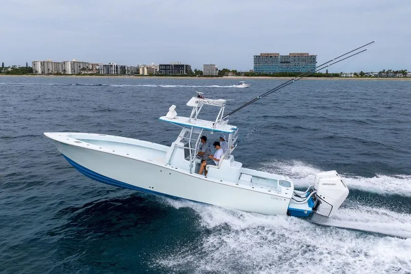 Slide: The Image of 2019 Conch 33 boat cruising on ocean near coastal buildings. - 7