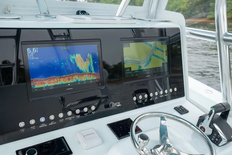 Slide: The Image of 2019 Conch 33 boat dashboard with Garmin navigation displays and steering wheel. - 24