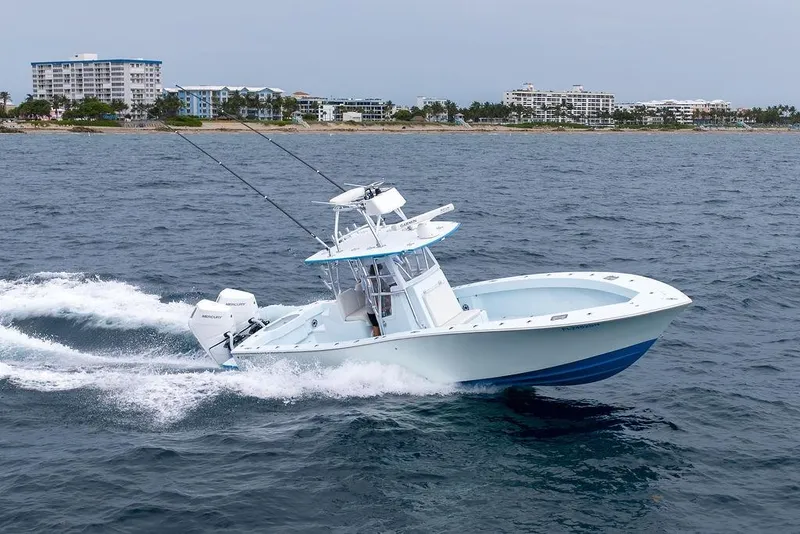 The Image of 2019 Conch 33 boat cruising on ocean near coastal buildings. - 3