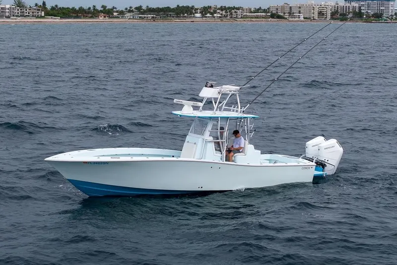 Slide: The Image of 2019 Conch 33 boat on ocean, with fishing rods and dual outboard motors. - 9