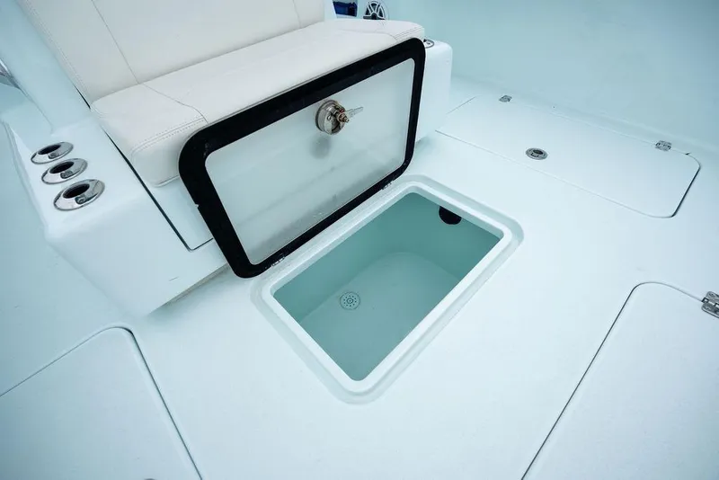 Slide: The Image of Open storage compartment on 2019 Conch 33 boat deck with seating and cup holders. - 18