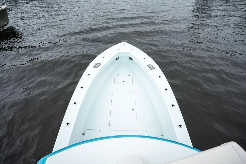 Slide: The Image of 2019 Conch 33 boat bow on calm water, showcasing sleek design and spacious deck. - 33