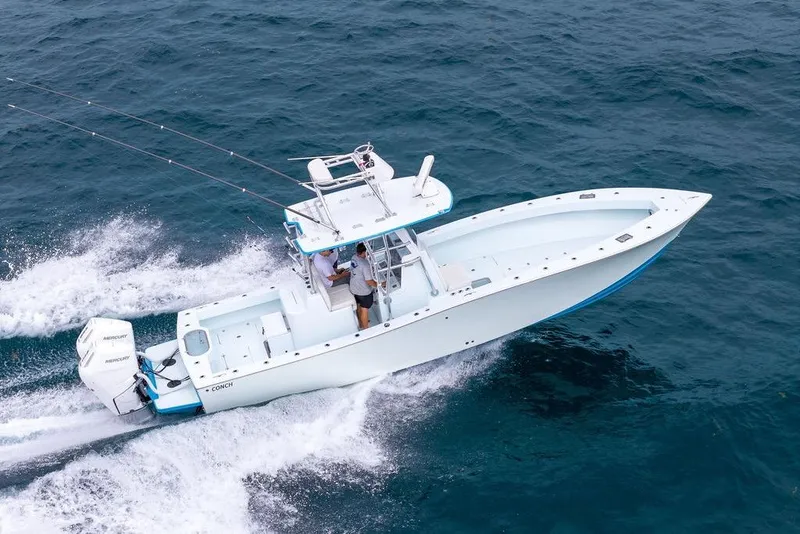 Slide: The Image of 2019 Conch 33 boat cruising on open water with dual Mercury engines. - 1
