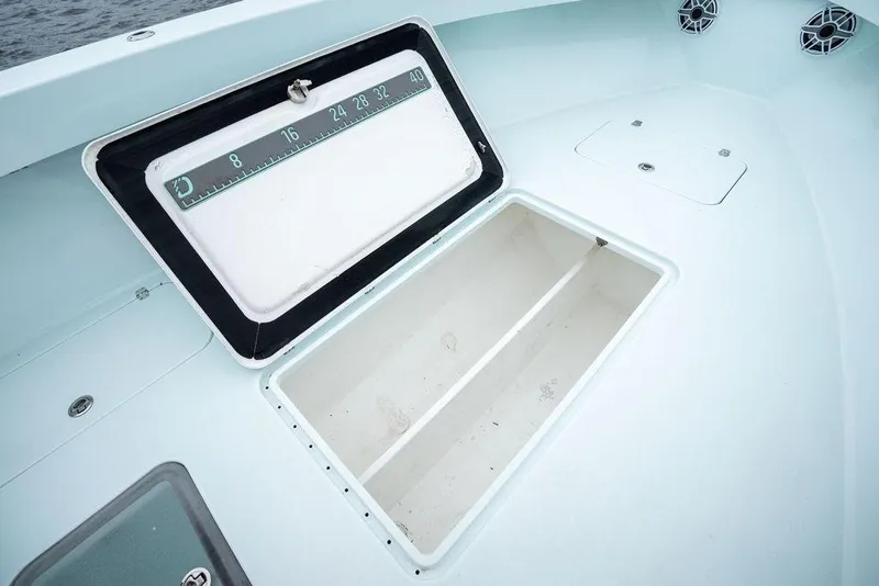 Slide: The Image of Open storage compartment on 2019 Conch 33 boat, featuring a built-in measuring scale. - 17