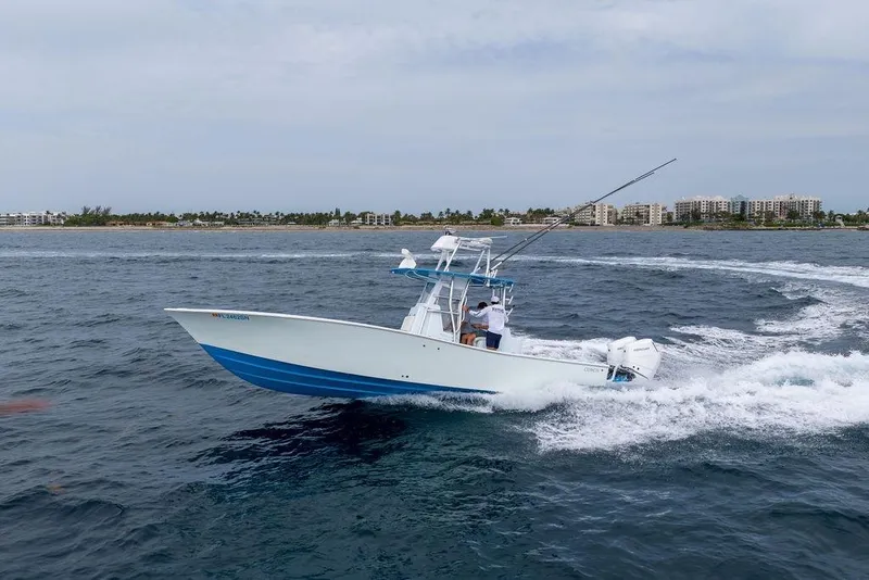 Slide: The Image of 2019 Conch 33 boat cruising on ocean near coastline with buildings in background. - 8