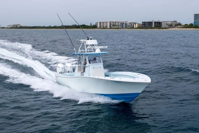 Slide: The Image of 2019 Conch 33 boat cruising on open water near coastal buildings. - 5
