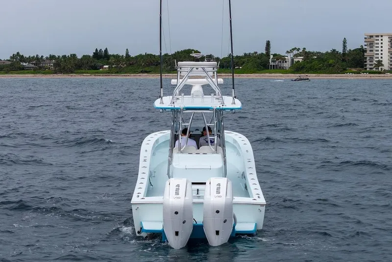 Slide: The Image of 2019 Conch 33 boat with dual engines cruising near a coastal shoreline. - 11