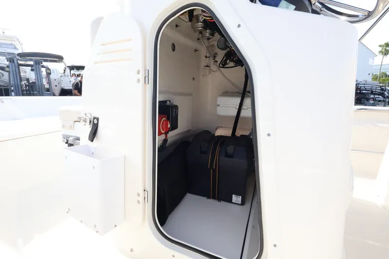 Slide: The Image of An open storage compartment on a Boston Whaler 150 Montauk boat, showing equipment and electronics. - 13