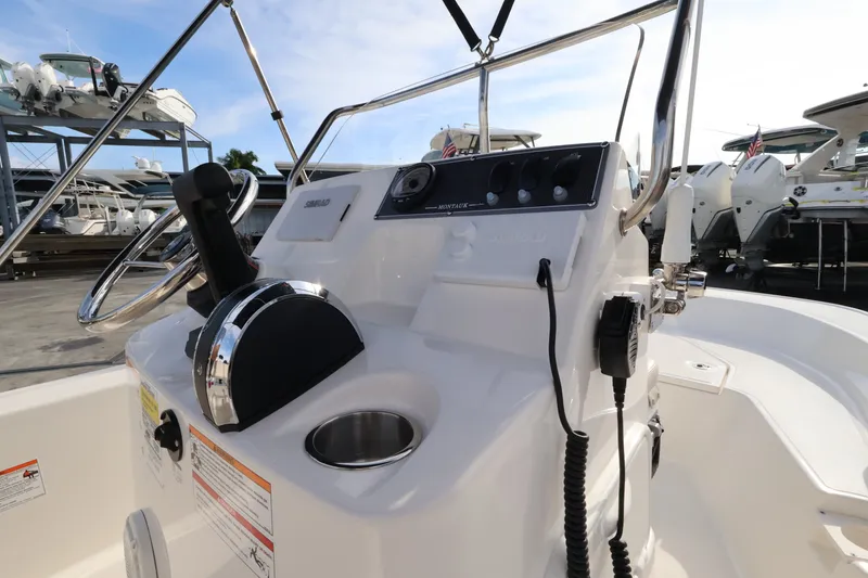 Slide: The Image of The image shows the helm of a 2027 Boston Whaler 150 Montauk, featuring a steering wheel and instruments. - 11