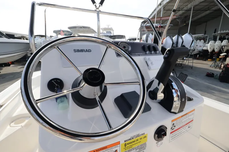Slide: The Image of Helm of a Boston Whaler 150 Montauk with Simrad controls and levers. - 10