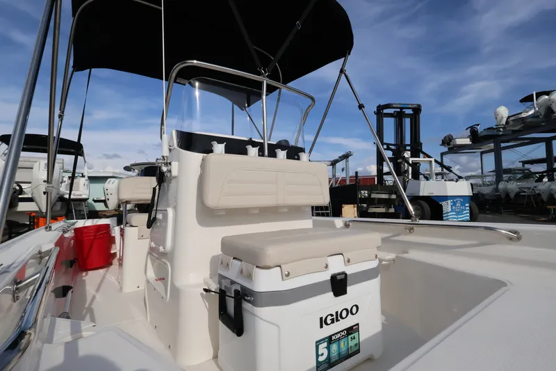 Slide: The Image of The image shows a Boston Whaler 150 Montauk boat with a Bimini top and Igloo cooler. - 12
