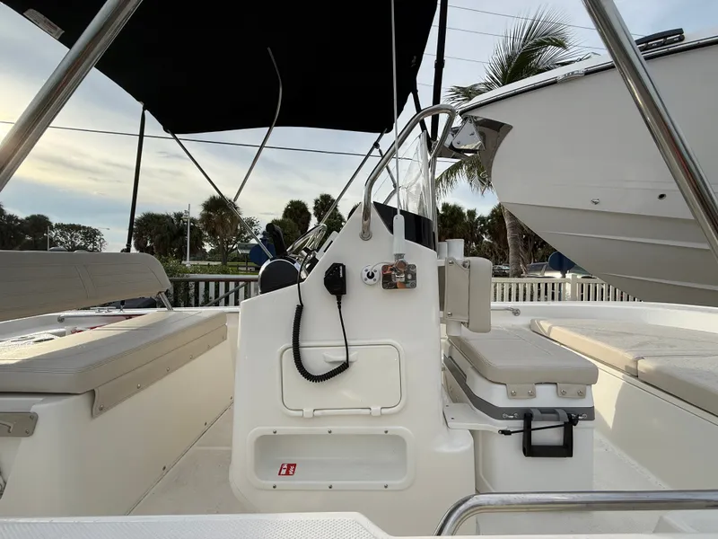 Slide: The Image of The image shows the cockpit of a 2027 Boston Whaler 150 Montauk with seating and a helm console. - 9