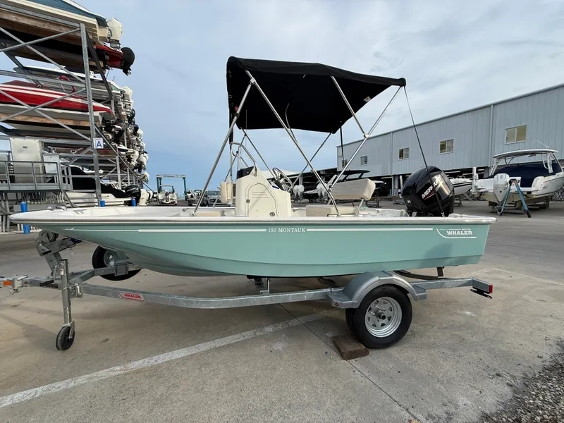 Slide: The Image of Boston Whaler 150 Montauk 2027 on a trailer with a black sunshade. - 4