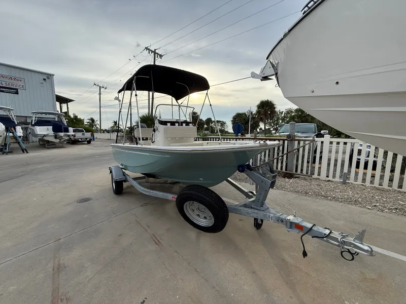 Slide: The Image of A 2027 Boston Whaler 150 Montauk on a trailer in a marina area. - 1