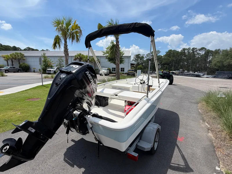 Slide: The Image of A 2018 Boston Whaler 130 Super Sport on a trailer, featuring a Mercury outboard motor. - 3