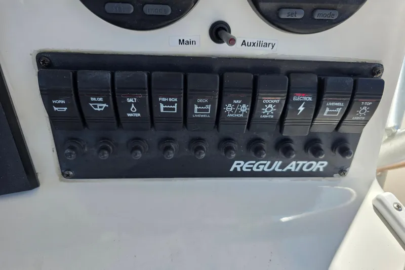 Slide: The Image of Control panel of a 2002 Regulator 26 Center Console boat with labeled switches. - 21